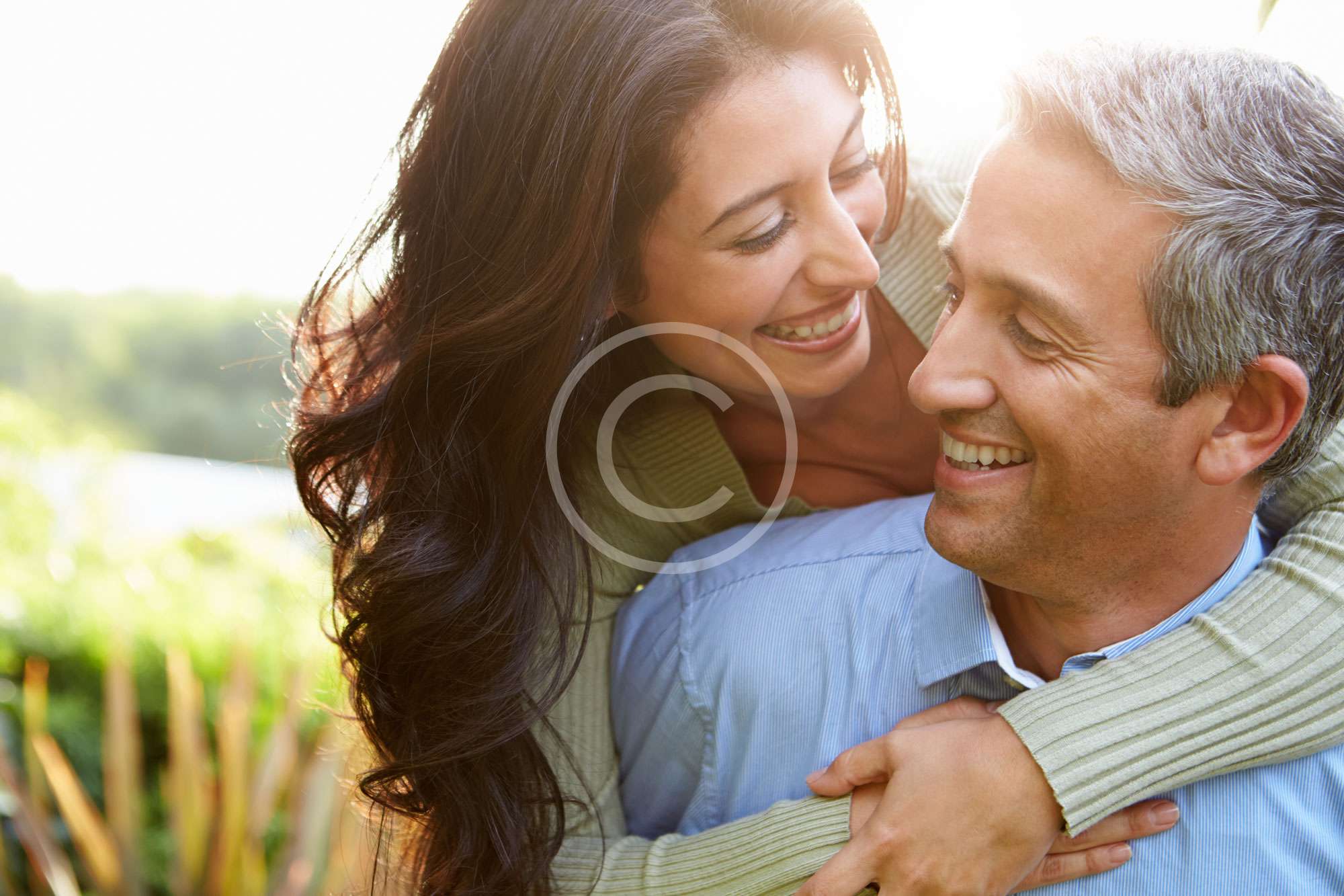 coppia di sposi si guarda e sorride abbracciata